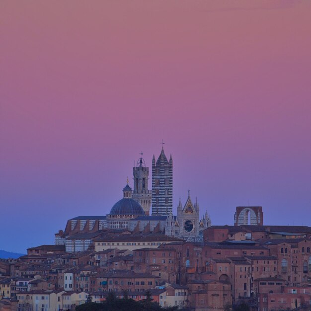 Buildings in city against sky during sunset