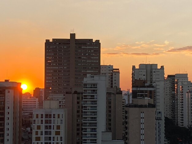 Buildings in city against sky during sunset