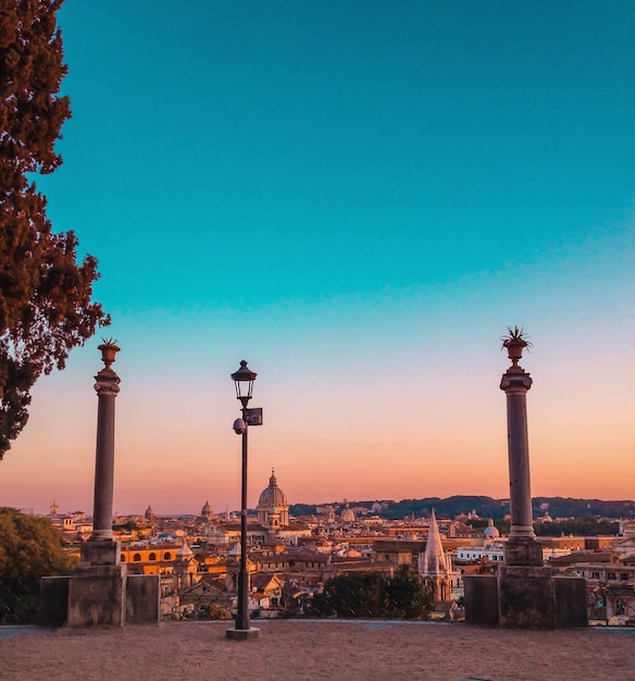 Buildings in city at clear sky during sunset