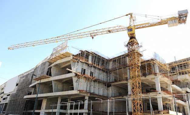 Buildings under construction and cranes under a blue sky