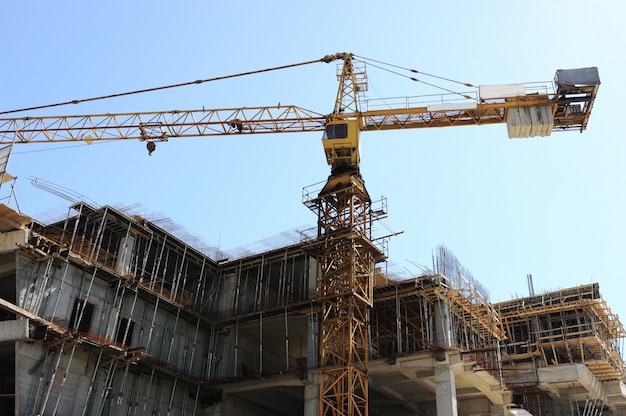 Buildings under construction and cranes under a blue sky