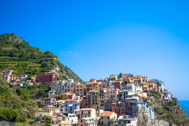 Buildings on mountains against clear blue sky