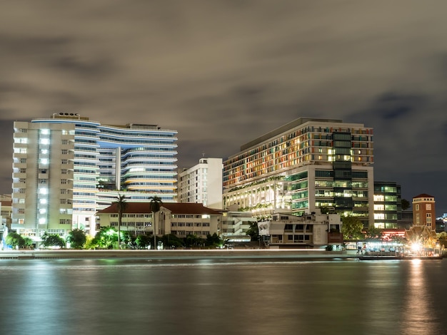 Buildings of Siriraj hospital along Chaophraya river in night light view in Bangkok Thailand