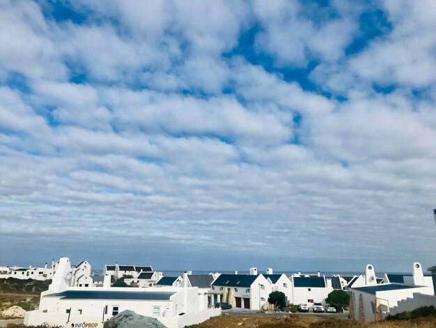 Buildings in town against cloudy sky