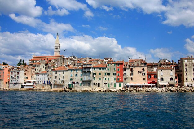 Buildings at waterfront against cloudy sky