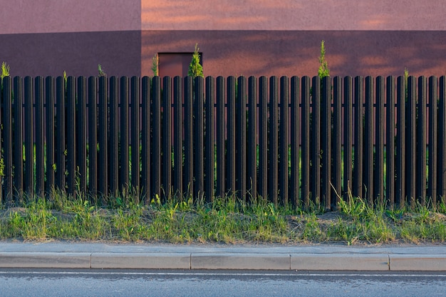 Photo built-in metal fence, gray and dark color photo from the street