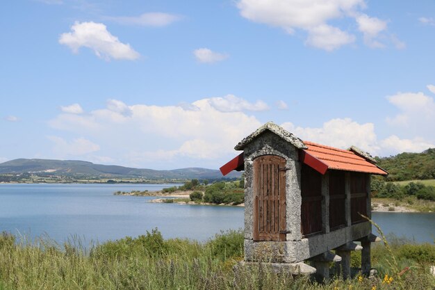 Built structure by lake against sky