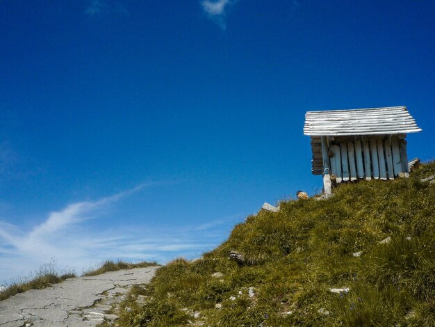 Built structure on land by trees against blue sky