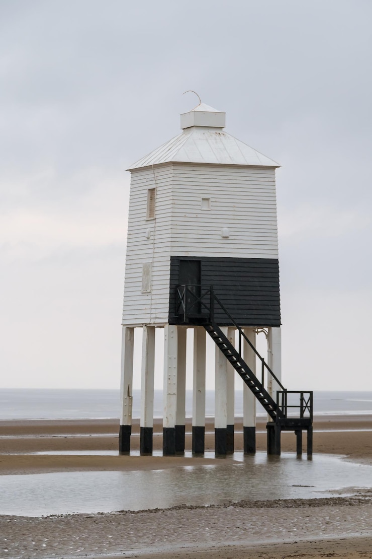 Photo built structure lighthouse on beach against sky