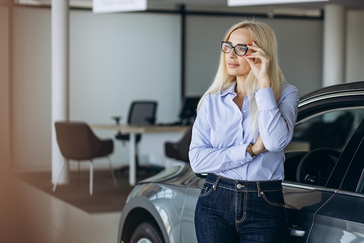 Фотография деловая женщина выбирает автомобиль в автосалоне
