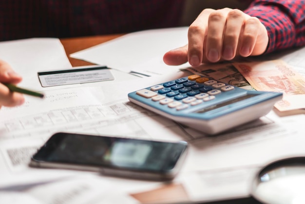 Buisnessman counting earnings with a calculator b