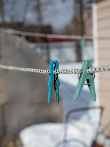 Buiten hangen plastic wasknijpers aan een touw. Close-up, onscherpe achtergrond