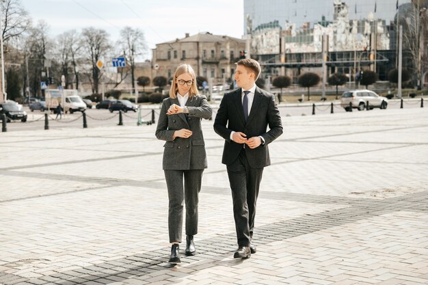 Buiten het kantoor lopen een paar zakenmensen in kantoorpakken door de stad