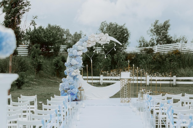 buiten huwelijksceremonie opgezet met witte stoelen en Boheemse bloemen