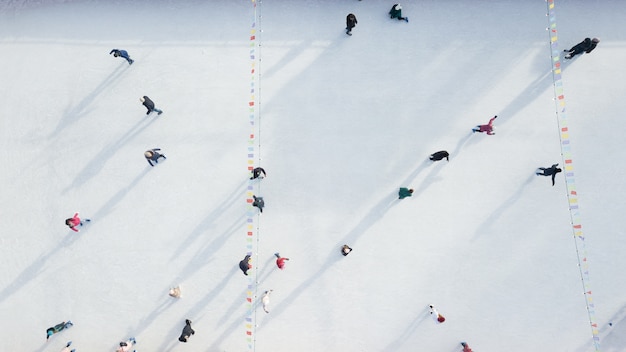 Buiten ijsbaan met mensen rijden op een winterse dag. Luchtfoto van de drone.