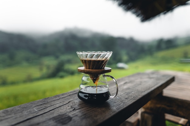 Buiten infuus koffiezetapparaat op houten tafel rijstveld achtergrond