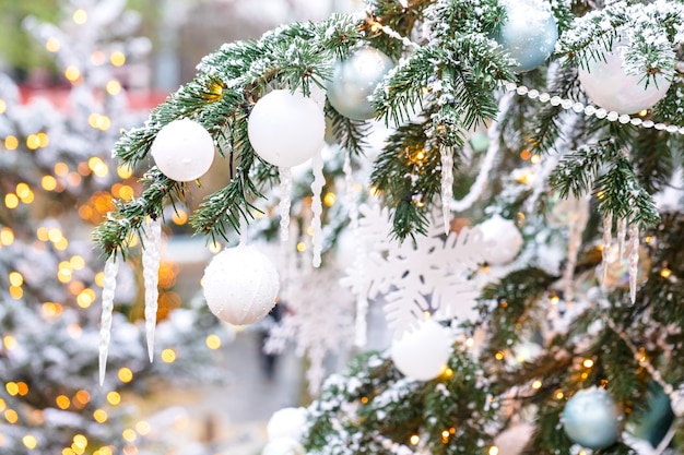 Buiten kerstboom met witte sneeuwvlokken en decoratie