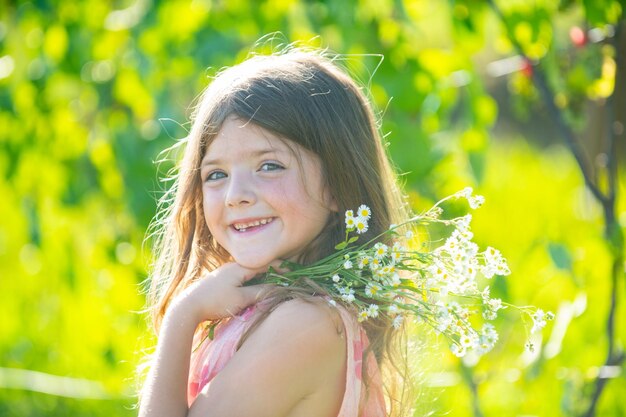 Buiten klein kind meisje portret op de weide kleine schattige jongen met bloemen in een tuin kinderen spelen buiten Kid spelen buiten Concept van gelukkige jeugd en zomer vrije tijd