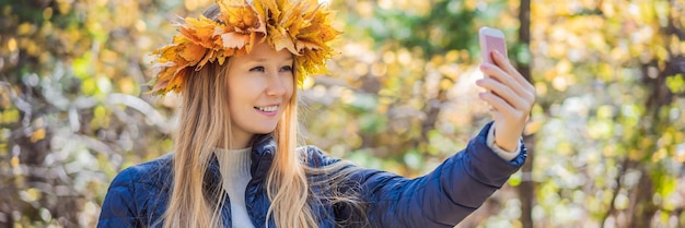 Foto buiten levensstijl close-up portret van charmante blonde jonge vrouw die een krans van de herfst draagt
