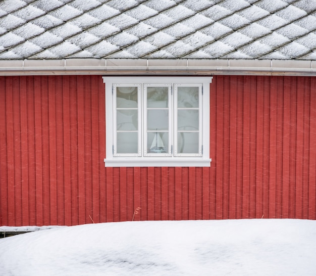 Buiten rode houten muur met raam en dak