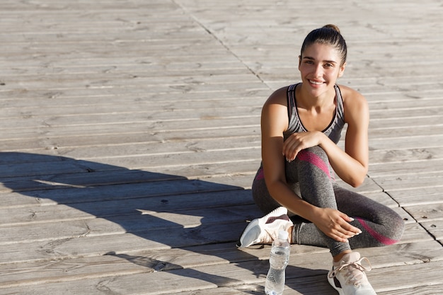 Foto buiten schot van gelukkige sportvrouw met pauze na training of joggen