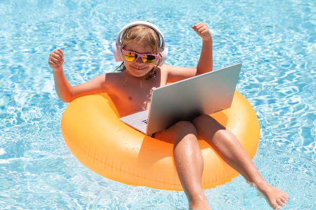 Buiten werken met laptop in zwembad kind op afstand werken op laptop in zwembad kleine zakenman aan het werk