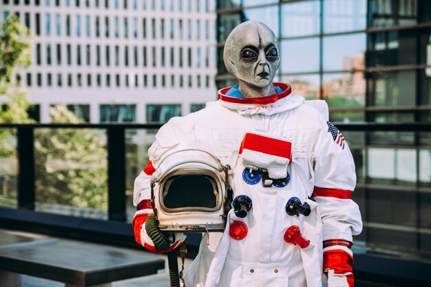 Buitenaardse ruimtevaarder in een futuristisch station. astronaut met ruimtepak wandelen in een stedelijk gebied