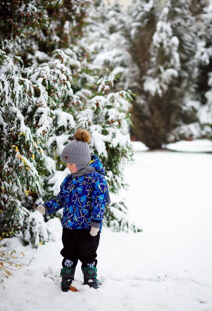 Foto buitendecoratie van de kerstboom schatje mooi klein meisje versiert besneeuwde kerstboom