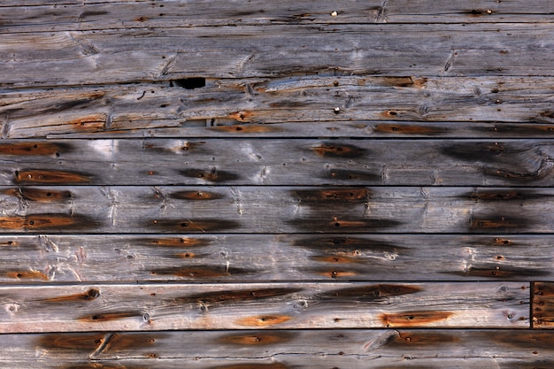 Buitenkant houten muur met roestige spijkers