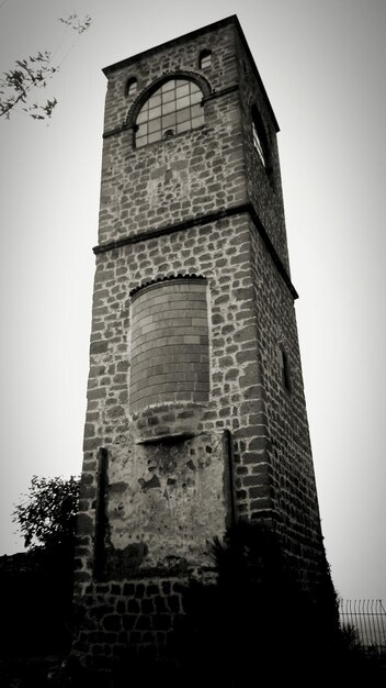 Foto buitenkant van de oude toren tegen een heldere hemel in de schemering