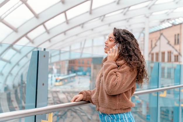 Buitenportret van een gelukkige vrouw die aan de telefoon praat in een stedelijke stad in Engeland