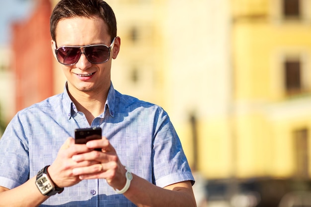 Buitenportret van man met mobiele telefoon op straat