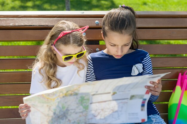 Buitenshuis portret kinderen toeristen. met kaart van de stad op de bank