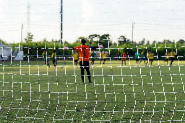 Buitenvoetballer die een voetbal schopt op een grassportveld