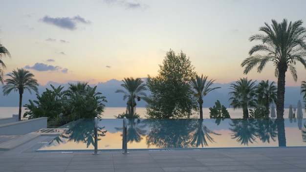 Buitenzwembad op resortscène met natuurachtergrond bij zonsondergang