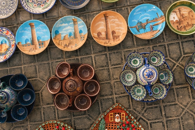 Photo bukhara uzbekistan december 2022 souvenir products plates and tea sets with bowls