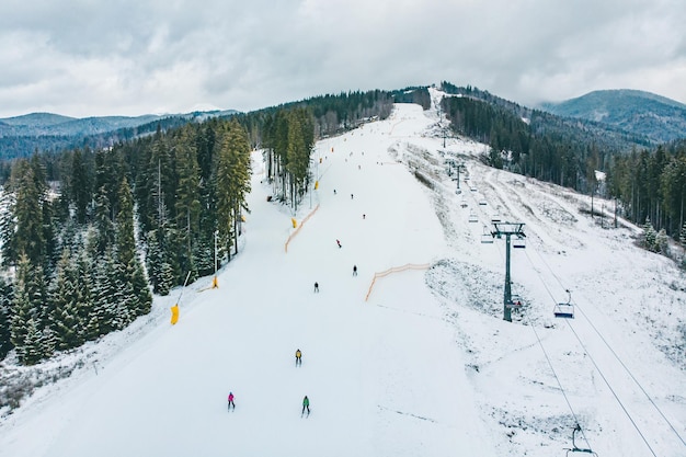 Photo bukovel ukraine december 9 2018 people skiing and snowboarding down by hill winter activity