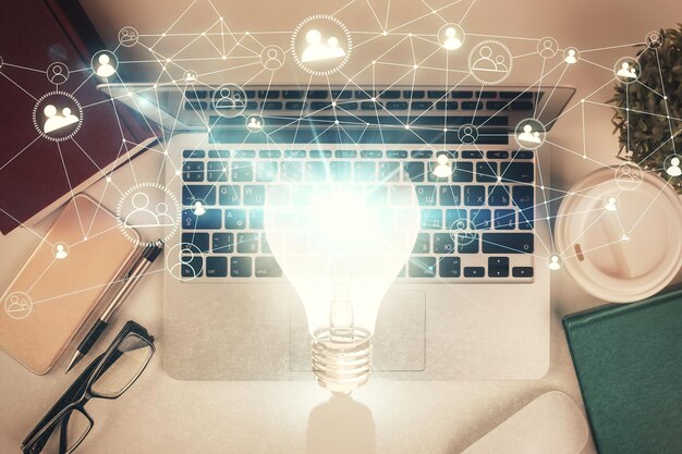 Foto disegno della lampadina sopra il computer sullo sfondo del desktop vista superiore esposizione doppia concetto idea