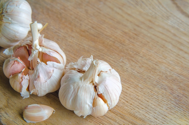 Bulbs of organic garlic and garlic cloves on natural wooden 