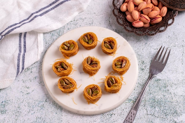 Foto bulbul kadayif con pistacchio kadayif baklava con ripieno di pistacchio su un pavimento di pietra dessert della cucina turca closeup nome locale antep fistikli bulbul kadeyif