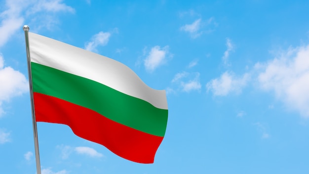 Bandiera della bulgaria in pole. cielo blu. bandiera nazionale della bulgaria