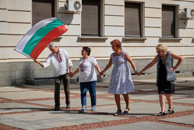 Foto bulgaria, sofia; 22 settembre 2023, persone con una bandiera bulgara ballano in strada per la celebrazione del giorno dell'indipendenza in una strada centrale della città - editorial