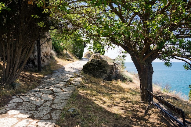 Bulgarije Stenen pad in de buurt van kliffen en ruïnes van het middeleeuwse fort in Kaap Kaliakra op een zonnige zomerdag met de zee en de blauwe lucht op de achtergrond