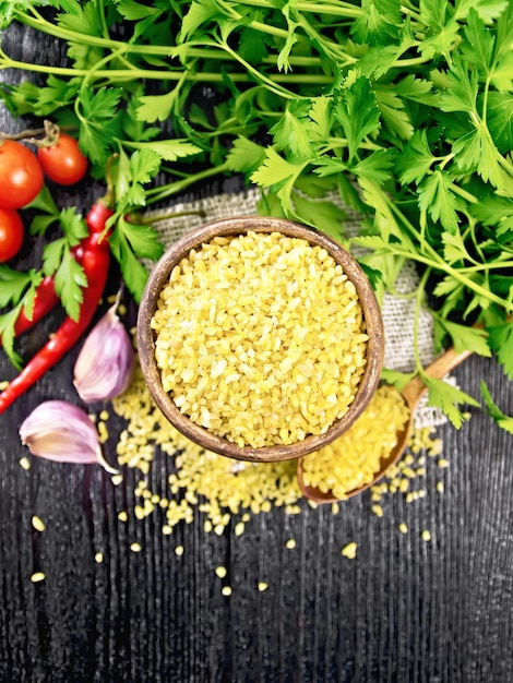 Bulgur in bowl with vegetables on board top