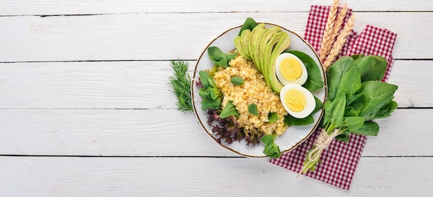 Bulgur met avocadospinazie en gekookt ei Op een houten achtergrond Bovenaanzicht Kopieer de ruimte