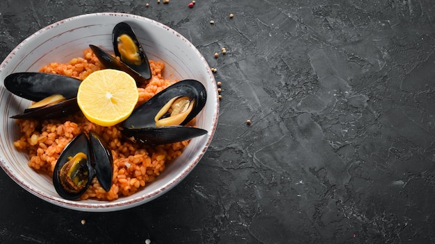 Bulgur met mosselen en tomatensaus in een bord Op de oude achtergrond Bovenaanzicht Vrije ruimte voor uw tekst