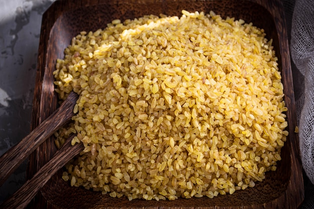 Bulgur wheat grains in a wooden bowl