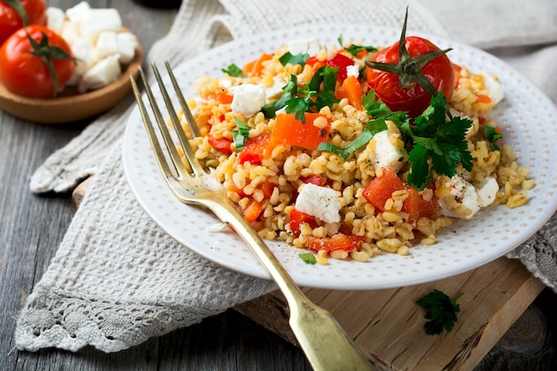 구운 고추, 토마토, 파슬리 및 페타 치즈를 곁들인 Bulgur