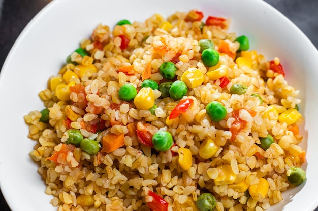 Bulgur with vegetables in a white plate close-up