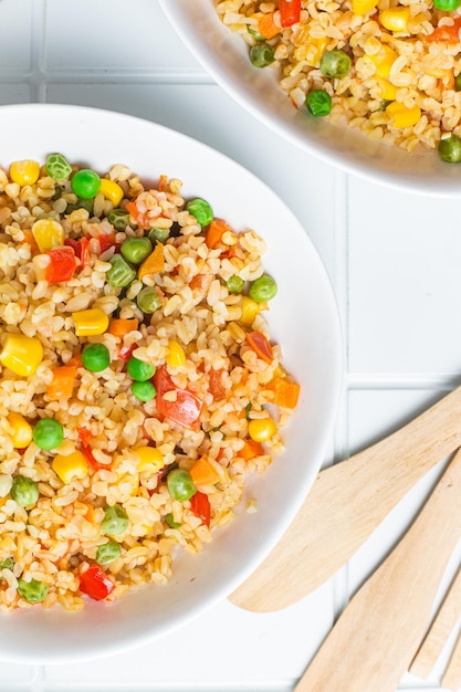 Bulgur with vegetables in a white plate close-up